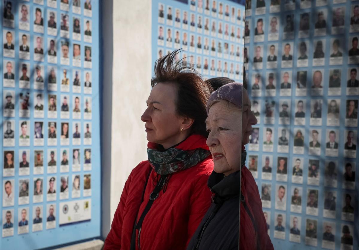 La gente visita el Muro del Recuerdo para conmemorar el Día de los Voluntarios en honor a los combatientes muertos que se unieron a las fuerzas armadas ucranianas.