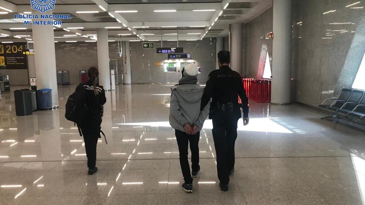 Dos policías trasladan al detenido.