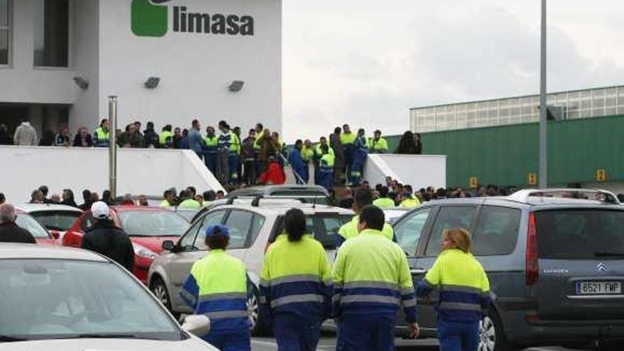 Un grupo de trabajadores concentrados ante la puerta principal de la empresa.