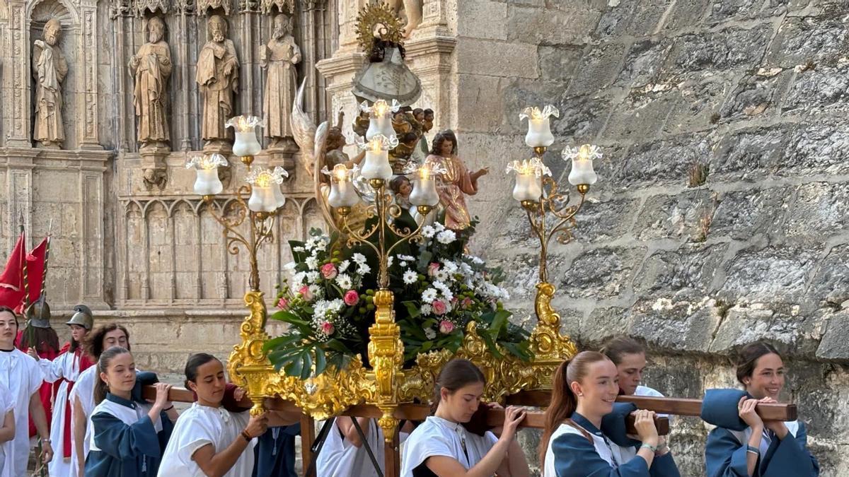 Las jóvenes portan la imagen durante un tramo de la procesión.