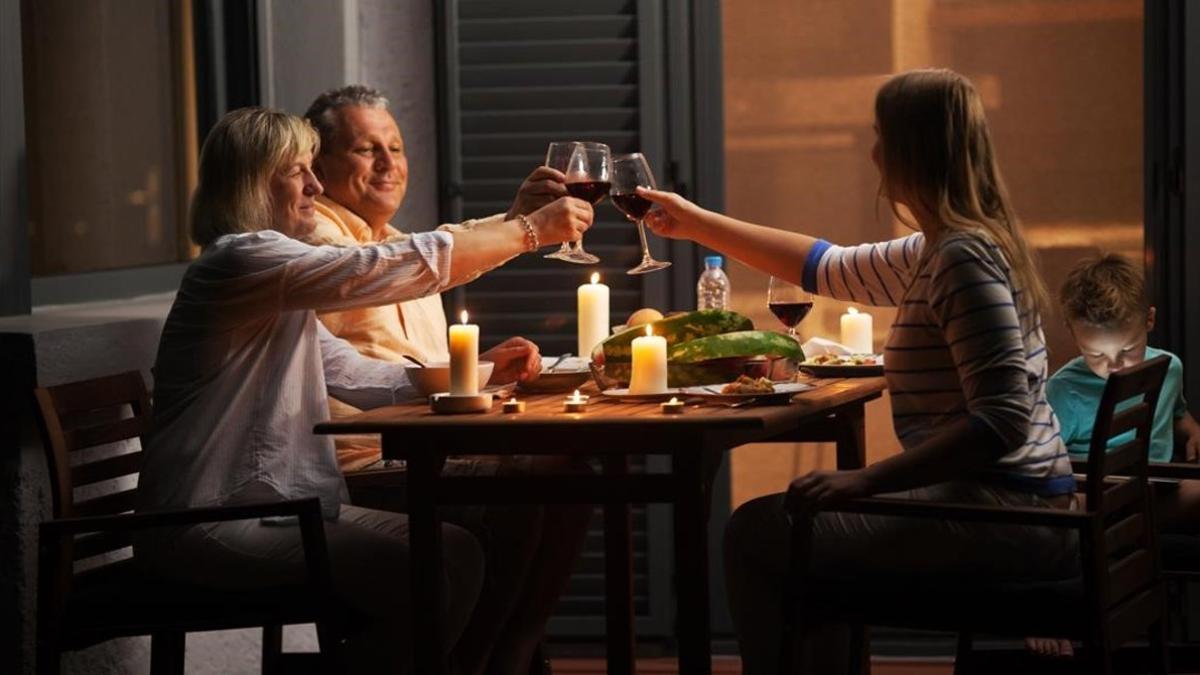 Una familia brinda mientras cena.