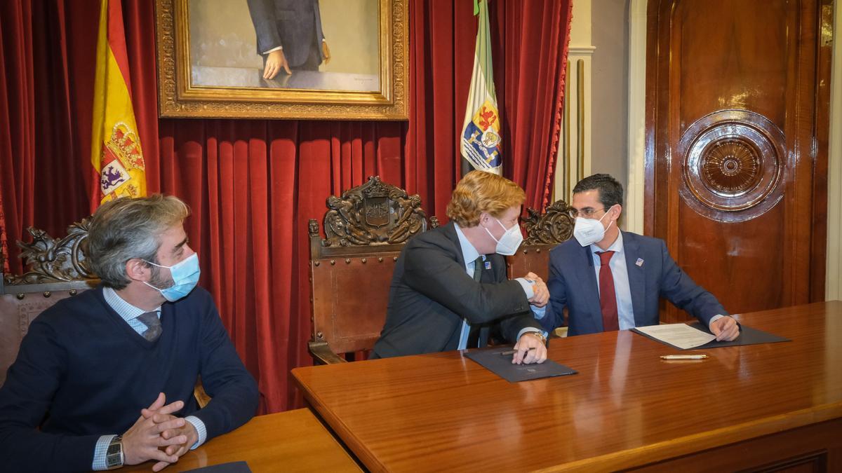 El alcalde y el director territorial de Ibercaja se dan la mano tras la firma del convenio, en la que también estuvo presente el concejal de Festejos.