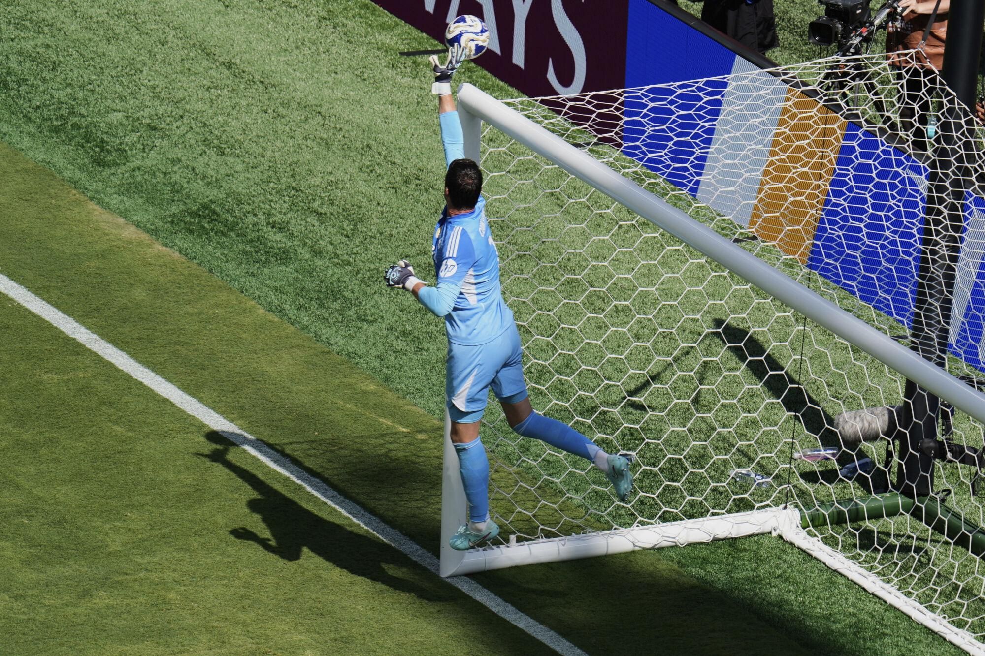 Real Madrid's Thibaut Courtois (1) makes a leaping save on a shot by Paris Saint-Germain during the Club World Cup semifinal soccer match between PSG and Real Madrid in East Rutherford, N.J., Wednesday, July 9, 2025. (AP Photo/Pamela Smith)