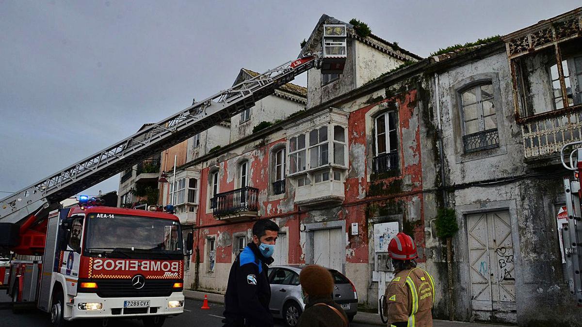 Los bomberos trabajando en una de las fachadas de las antiguas viviendas de Massó.