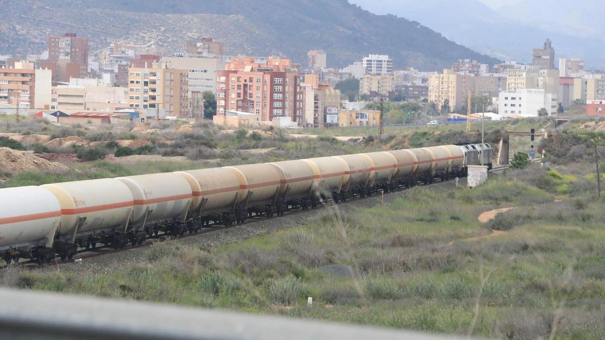 Un largo tren de mercancías pasando por la ciudad de Cartagena.