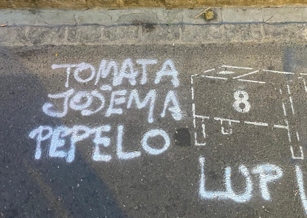 Una pintada en el suelo de la calle Mayor que indica donde se tiene que poner el cajón número 8 y los nombres de sus integrantes.