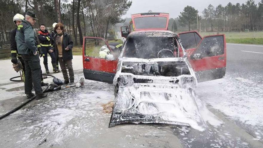 Bomberos, Guardia Civil, Emerxencias y la dueña del coche que ardió, ayer en Loimil. // Bernabé / Javier Lalín