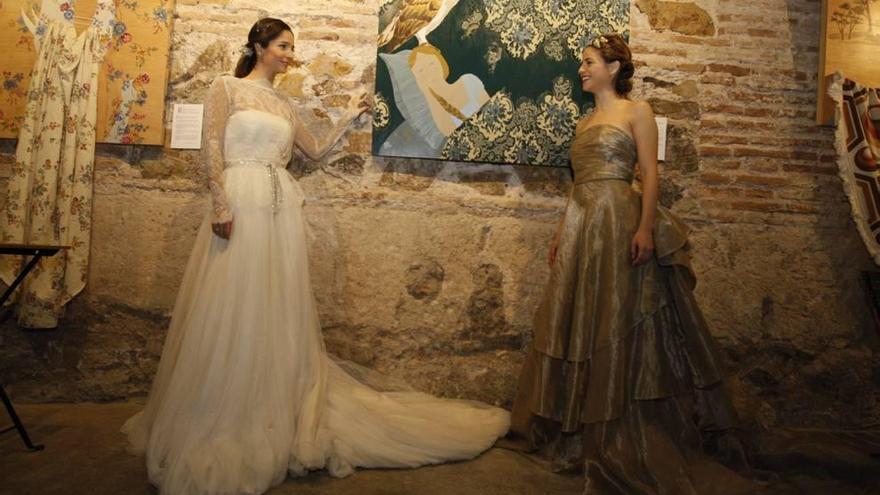 Elena Medina y Talia del Val posan con dos diseños de Paula del Vas en el Espacio Pático y ante las obras de la artista Marta Abellán