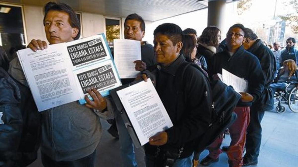 Miembros de Stop Desahucios presentan firmas por la paralización en los juzgados de Madrid.