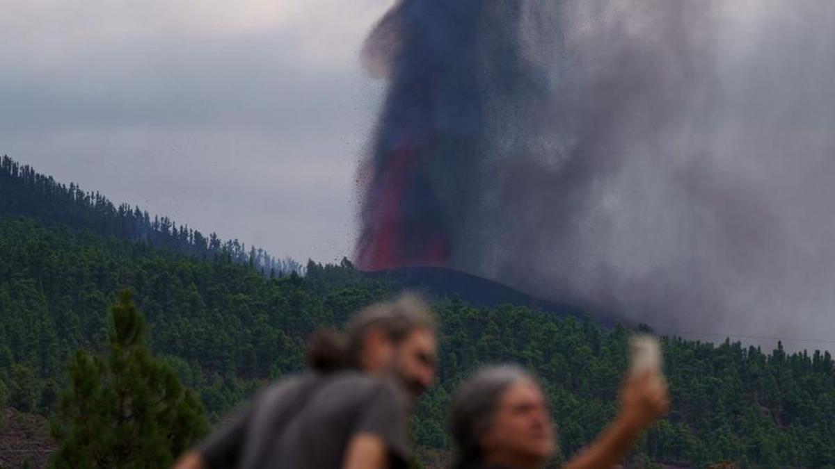 Dos personas se hacen un selfie delante del volcán de La Palma.