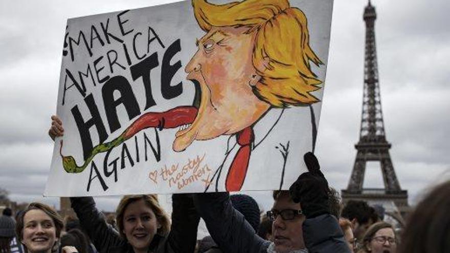 Manifestants sostenint cartells i pancartes anti-Trump al voltant de la torre Eiffel, ahir a París