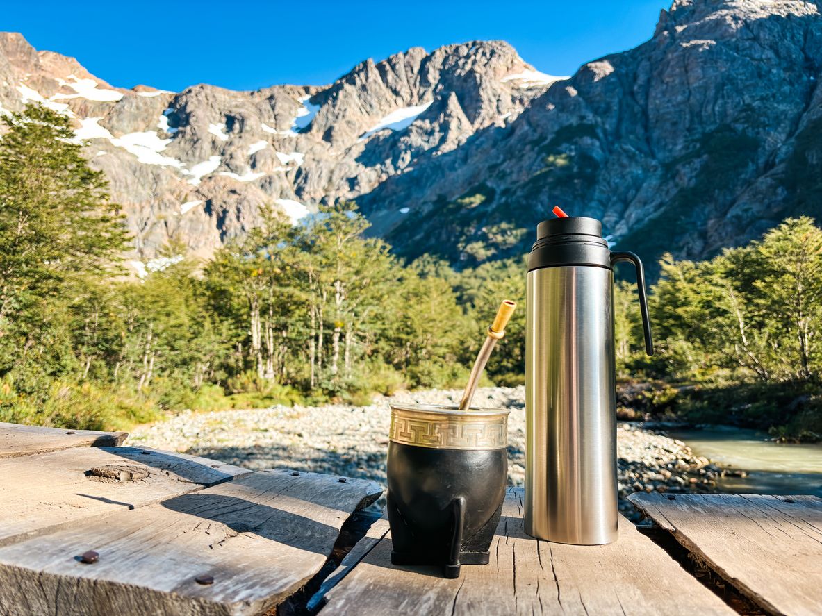 Mate y termo con telón de fondo montañoso, El Bolsón, Argentina.