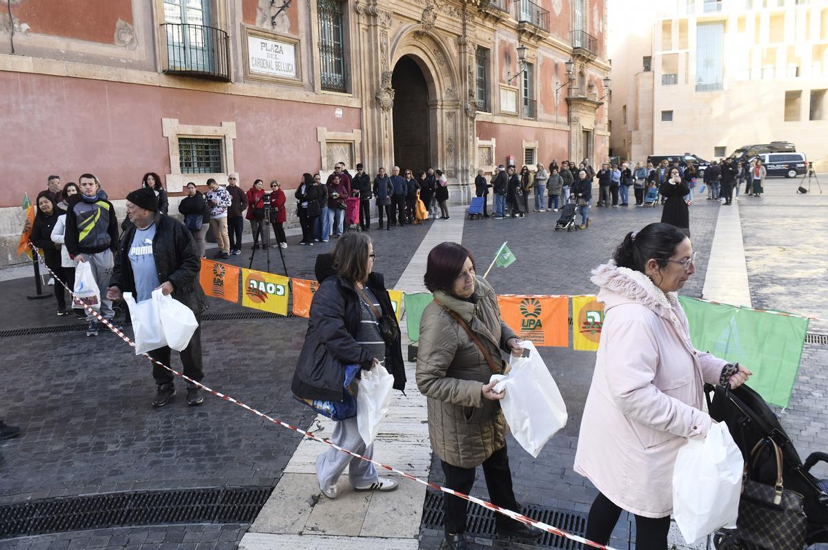 Largas colas para obtener los productos en el reparto de la plaza Belluga de Murcia.