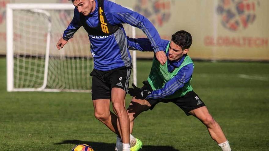 Jonathan Vila controla la pelota en presencia de Jorge Ortiz en una sesión en El Requexón.