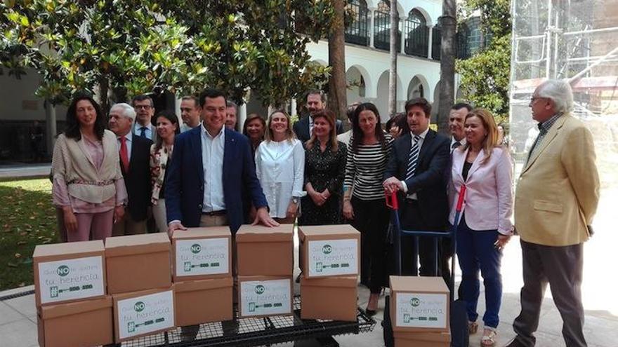 Juanma Moreno, junto a los diputados del PP-A y las cajas de firmas.