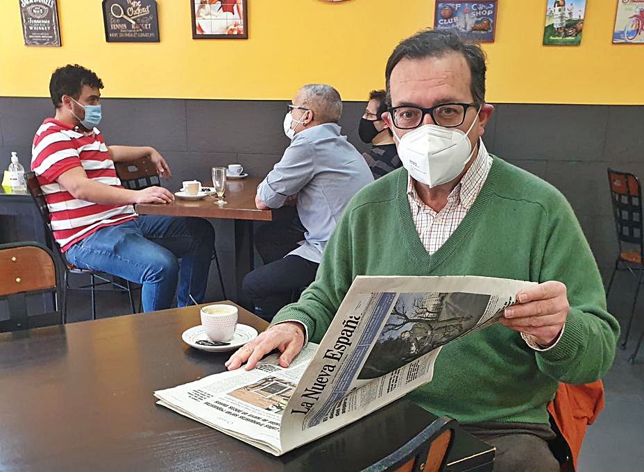 Luis Serrano, leyendo LA NUEVA ESPAÑA en una cafetería de Oviedo. 