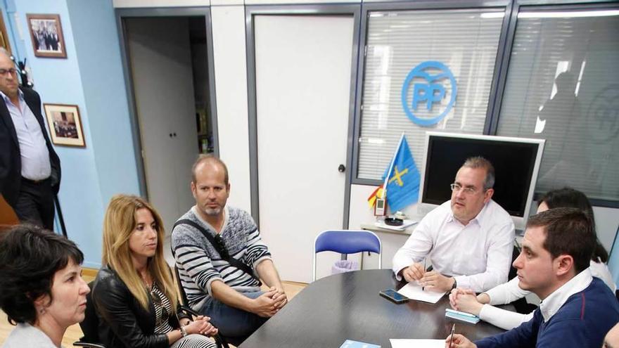 A la derecha, el diputado del PP David González Medina, con concejales populares; a la izquierda, representantes de las educadoras infantiles.