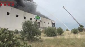 Bomberos trabajan en la extinción de un incendio en una fábrica de Barcelona. 