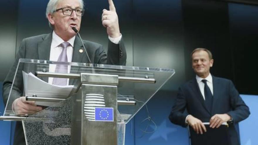 Juncker es dirigeix als mitjans després de la reunió mentre Tusk l&#039;observa.