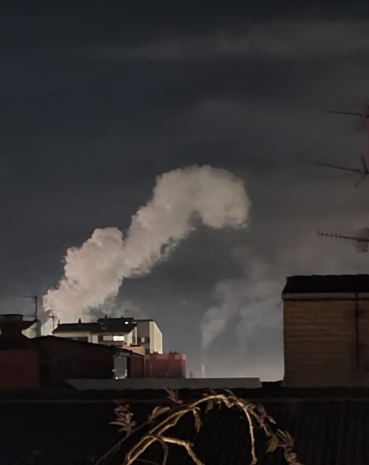 Al fondo, humareda en la zona industrial de Gijón, en una imagen tomada desde La Calzada poco antes de la una de la madrugada de este sábado.