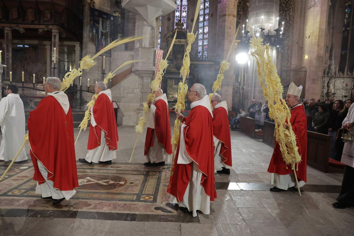 El obispo de Mallorca y los canónigos entran en la Seu esta mañana para celebrar la eucaristía tras la procesión de las palmas.