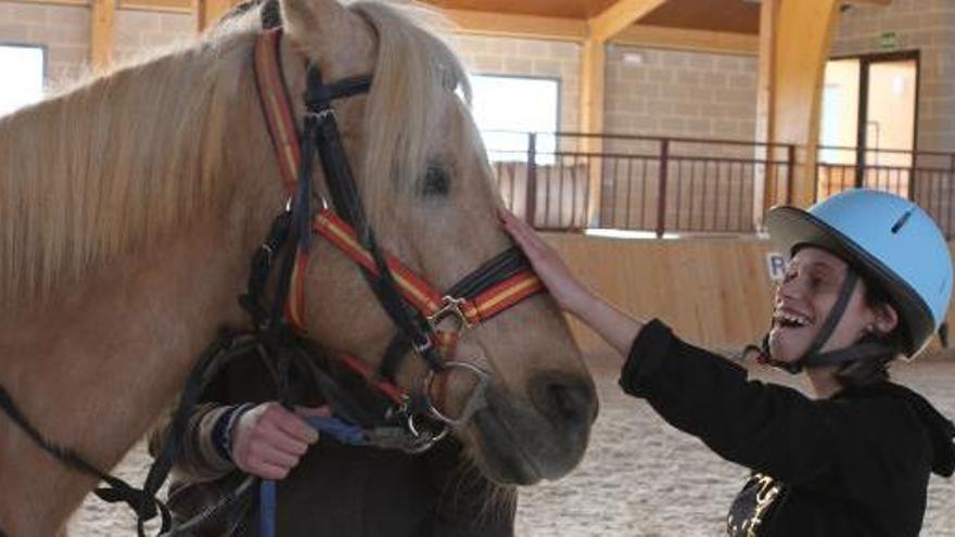 Una joven de Asprosub acaricia a su caballo.