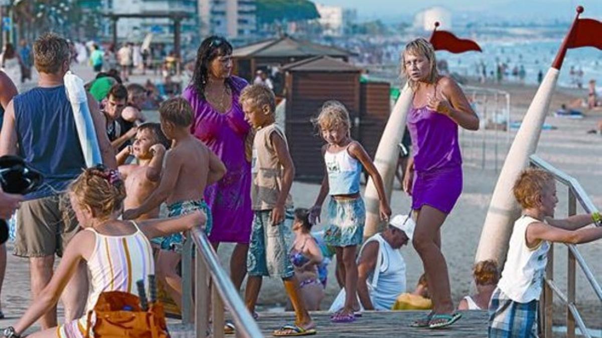 Un grupo de turistas rusos se va de la playa de la Pineda, ayer.