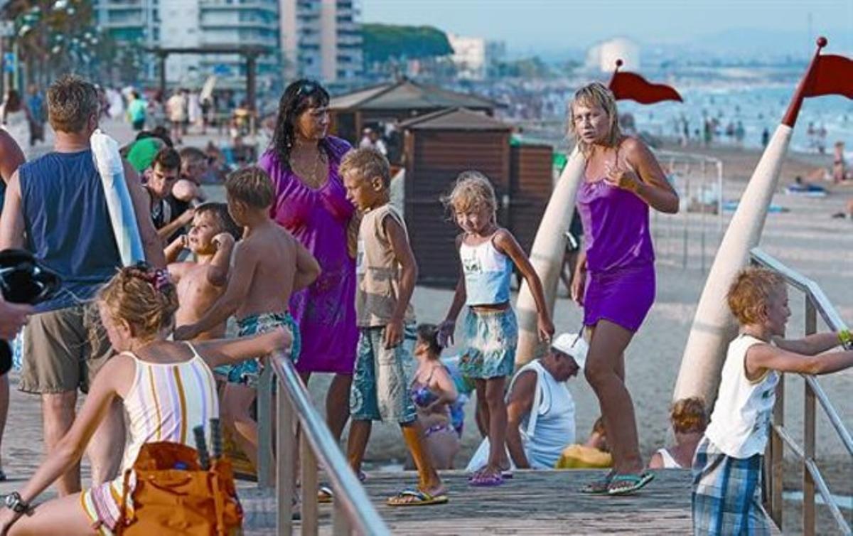 Un grupo de turistas rusos se va de la playa de la Pineda, ayer.