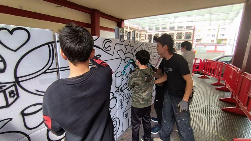 César Frey enseña a utilizar spray de pintura a alumnos de un taller de graffiti en el colegio Aniceto Sela de Mieres. | D. O.