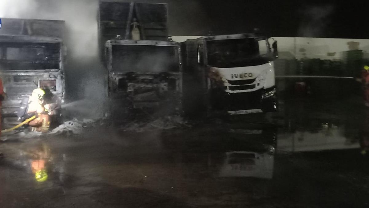 Los bomberos sofocan el incendio de los tres camiones.