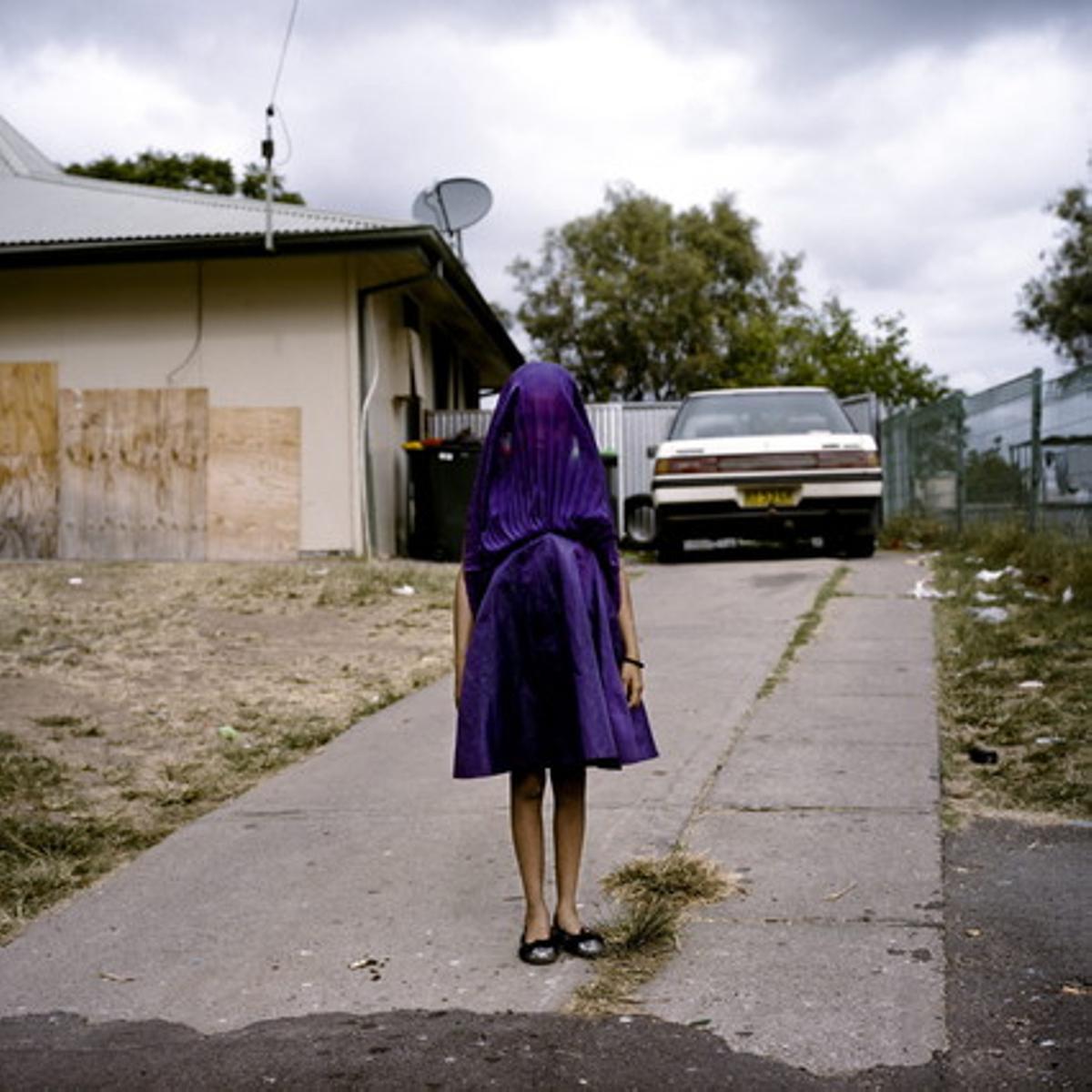 La australiana Raphaela Rosella, ganadora del primer premio en la categoría individual de retratos, con esta niña llamada Laurinda mientras espera el autobús a su colegio vestida con un traje morado, en Moree (Nueva Gales del Sur). 