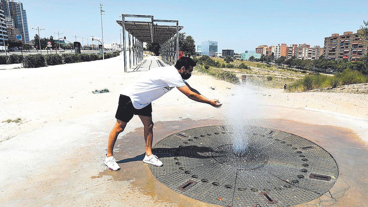 Un zaragozano se refresca, este sábado, en una de las fuentes del entorno de la estación del ave de la capital.