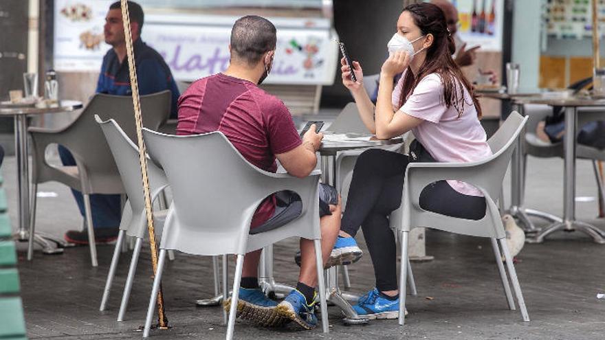 Dos jóvenes, en una terraza de Santa Cruz de Tenerife.