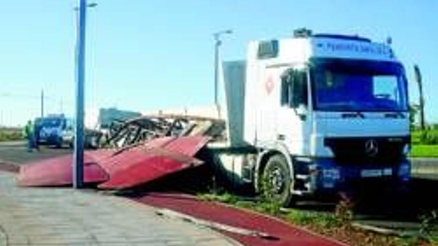 La carga de un camión vuelca al coger una rotonda