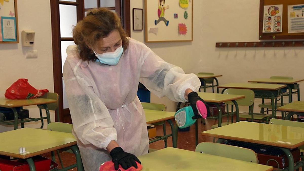 Una mujer limpia una clase en un centro educativo de Córdoba.