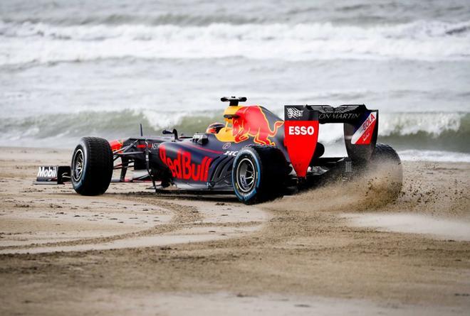 Motos y coches de carreras del equipo Red Bull circulan por la playa de Scheveningen, Países Bajos, durante la grabación de un anuncio.