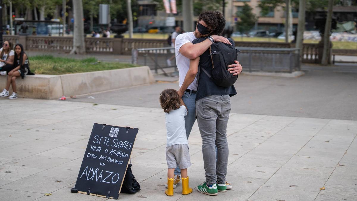 Un padre se para a abrazar con su hijo.