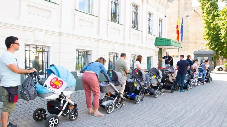 Padres españoles con sus bebés a las puertas de la Embajada española en Kiev.