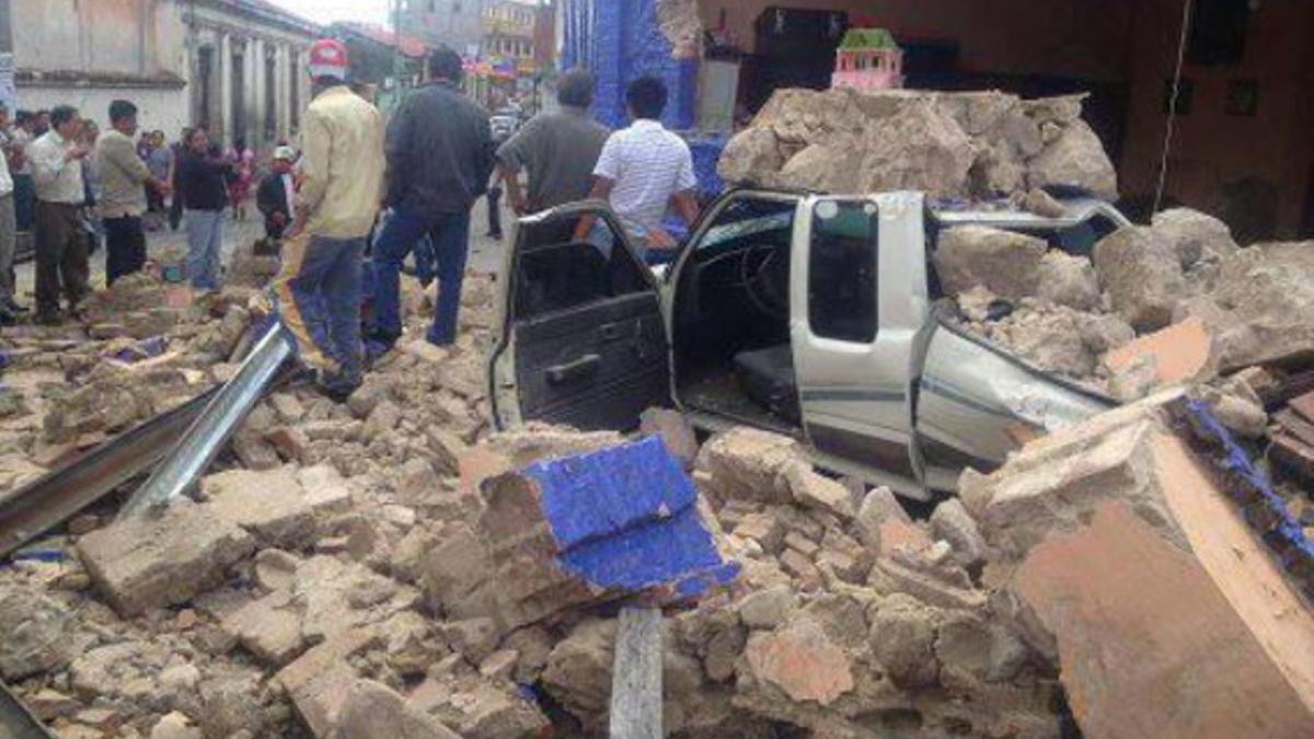 Un grupo de guatemaltecos observa los daños causados por el terremoto de este miércoles.