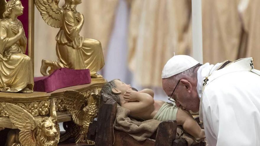 El Papa besa una imagen del Niño Jesús.