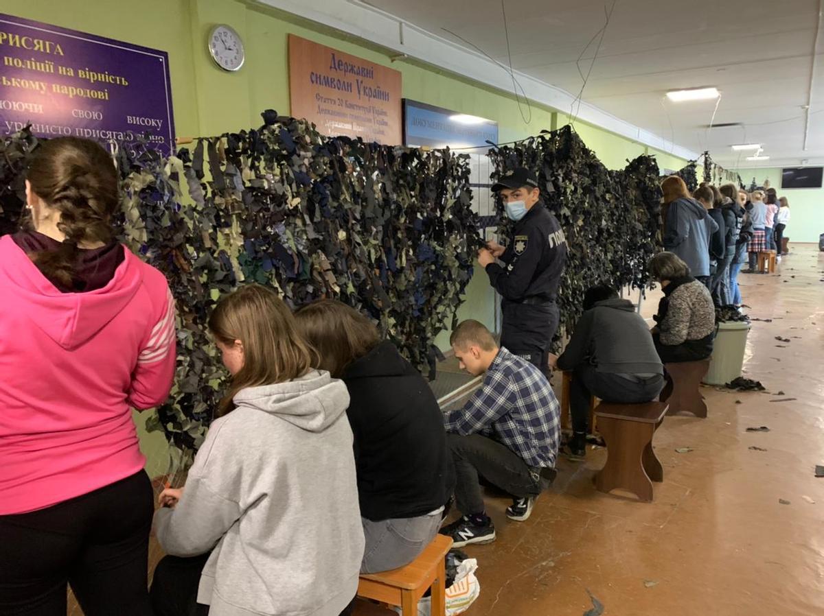 En el Instituto de Investigación y Educación Krivnyy Rih, civiles cortan trozos de tela y preparan redes de camuflaje para proteger a los blindados ucranianos
