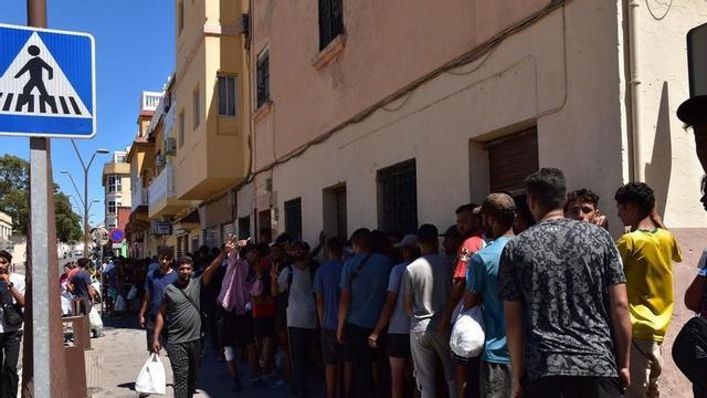 Diverses persones fan cua en un punt d’atenció humanitària, el 5 d’agost del 2026, a Ceuta.