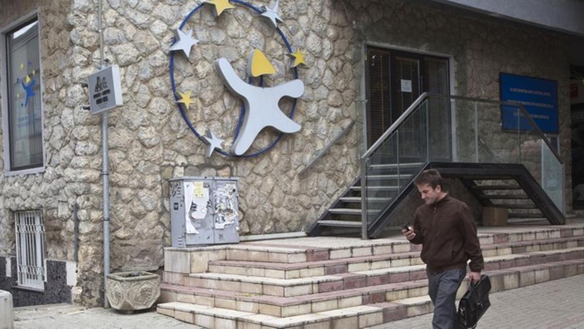 Un kosovar observa su móvil frente a la oficina cultural y de información de la UE en Pristina (Kosovo), este martes.