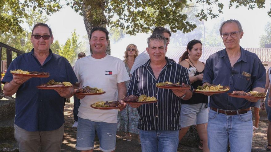 Asistentes a la fiesta gastronómica posan con sus chuletones en Garabás. |  Roi Cruz