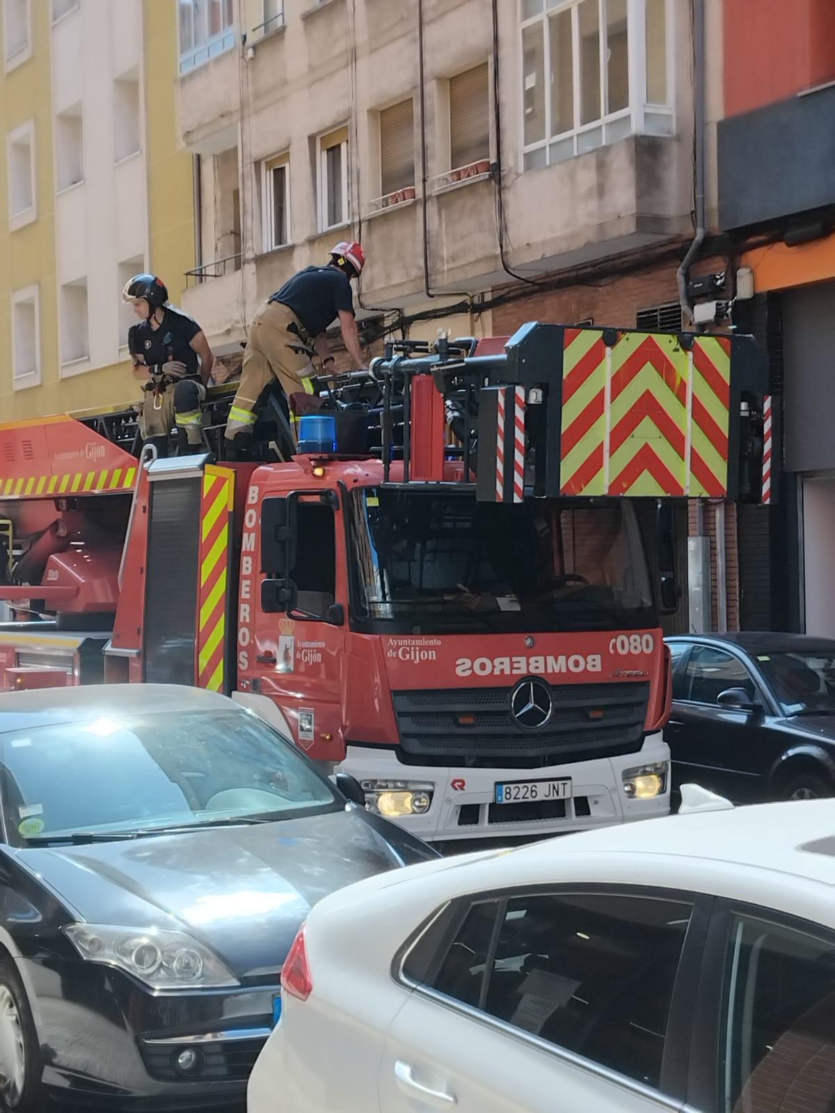Los bomberos, preparados en la autoescalera para acceder al interior de la vivienda.
