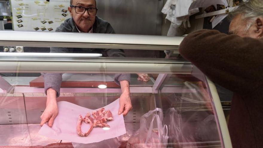 Un carnicero prepara unas piezas de carne en su puesto del Mercado de Verónicas, en Murcia. | JUAN CARLOS CAVAL