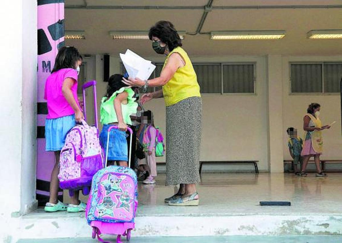 Una profesora controla el acceso de niñas a un colegio durante el pasado curso. | ÁLEX ZEA