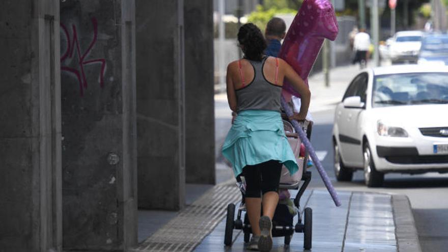 Una mujer pasea con un carrito de bebé