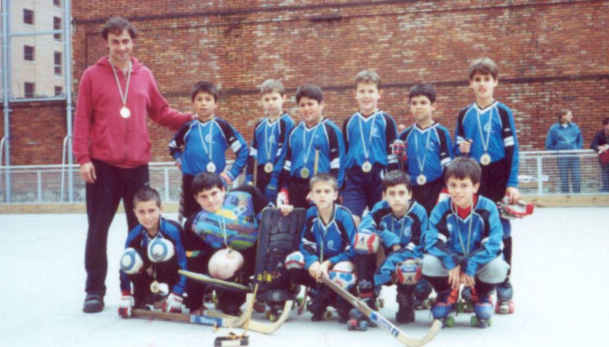 Ángel García, quinto por la izquierda agachado, con sus compañeros, tras quedar campeones de la liga prebenjamín en el año 2000. En el detalle, durante un partido. | TELECABLE HOCKEY