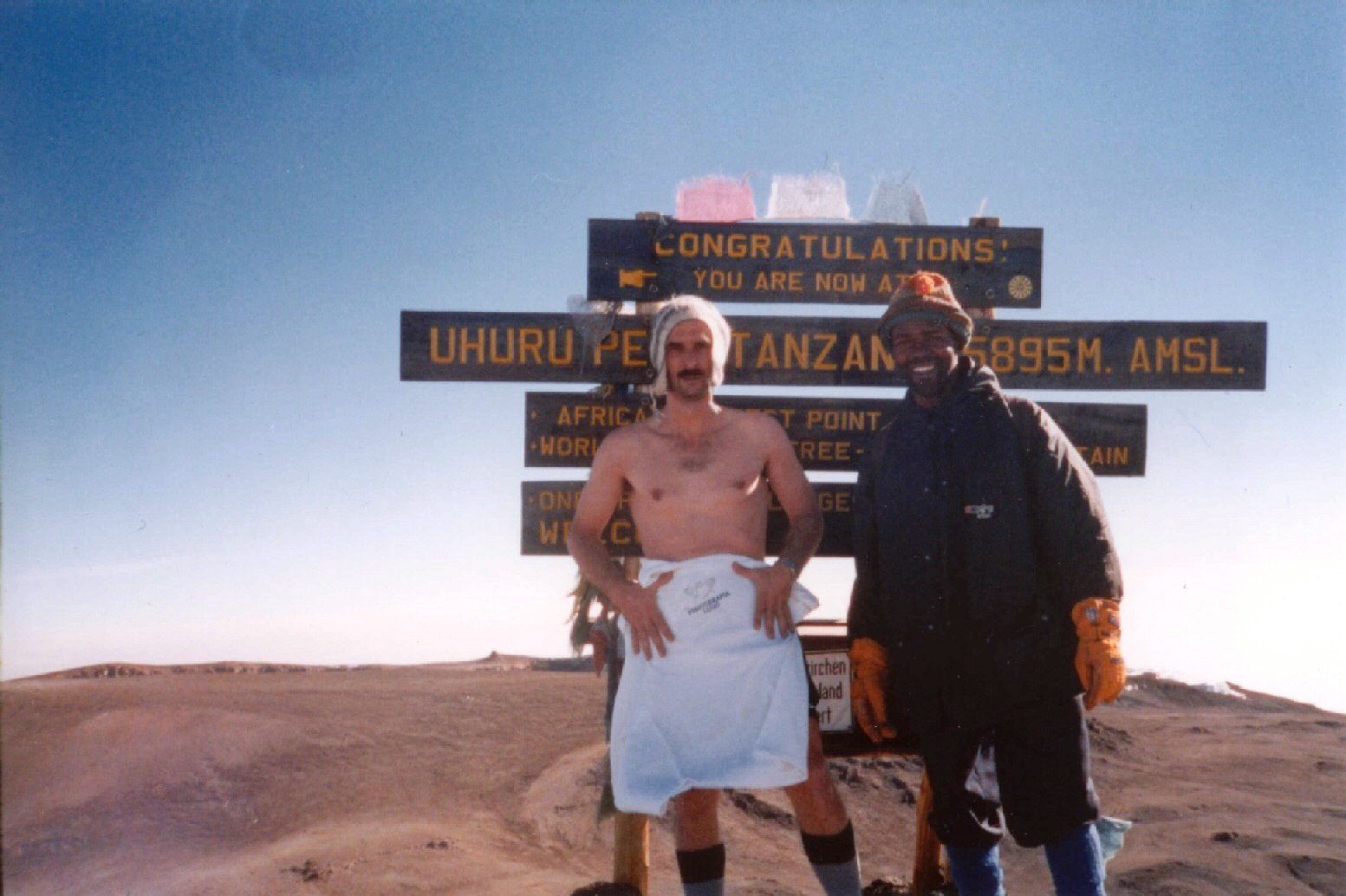 En la cumbre del Kilimanjaro semidesnudo y acompañado de su guía (2001).